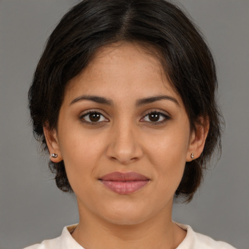 Joyful latino young-adult female with medium  brown hair and brown eyes