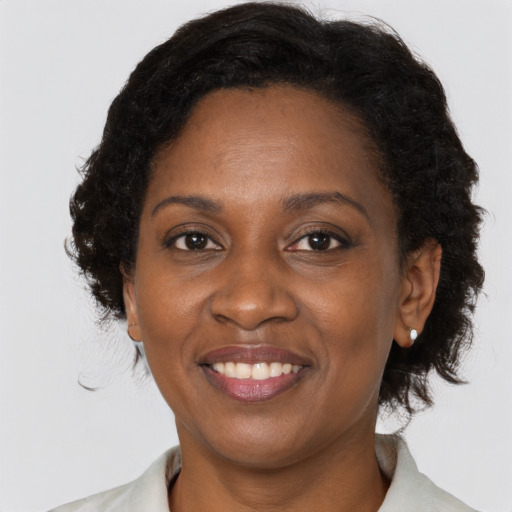 Joyful black adult female with medium  brown hair and brown eyes