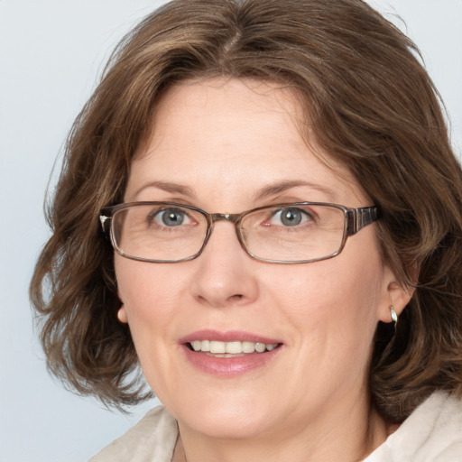 Joyful white adult female with medium  brown hair and blue eyes