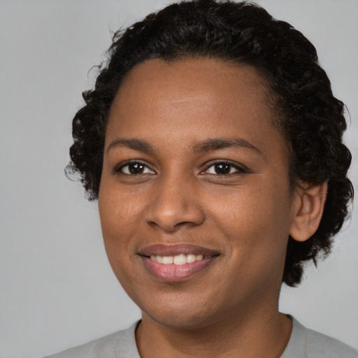 Joyful black young-adult female with short  black hair and brown eyes