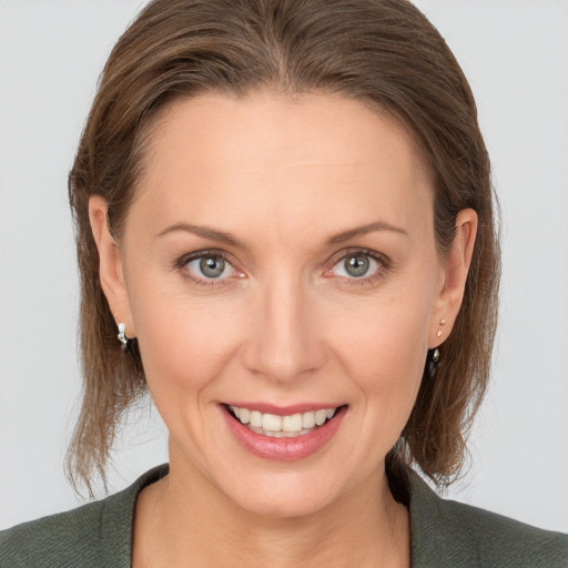 Joyful white young-adult female with medium  brown hair and grey eyes