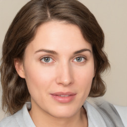 Joyful white young-adult female with medium  brown hair and green eyes