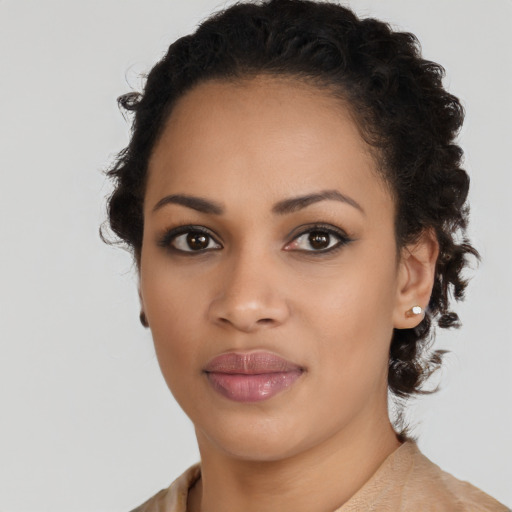 Joyful black young-adult female with long  brown hair and brown eyes