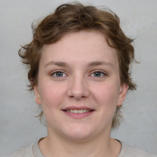 Joyful white young-adult female with short  brown hair and blue eyes