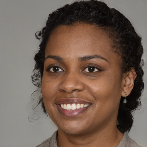 Joyful black young-adult female with medium  brown hair and brown eyes