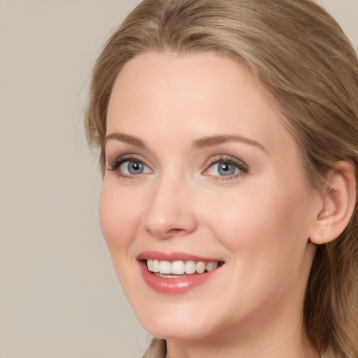 Joyful white young-adult female with long  brown hair and blue eyes