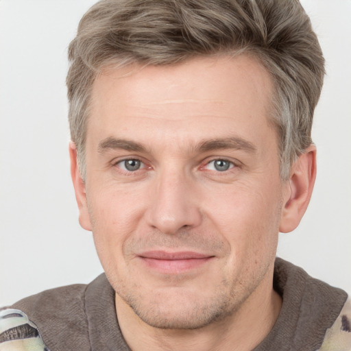 Joyful white adult male with short  brown hair and grey eyes