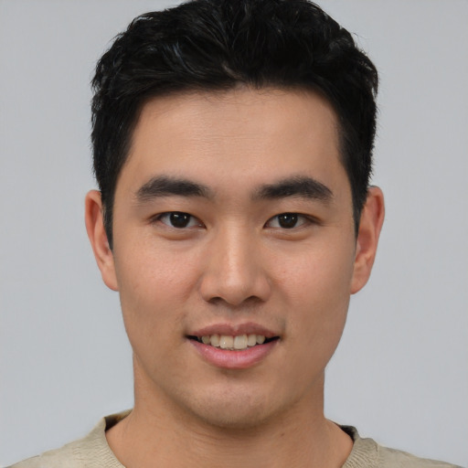 Joyful asian young-adult male with short  black hair and brown eyes