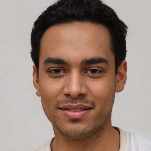 Joyful latino young-adult male with short  black hair and brown eyes