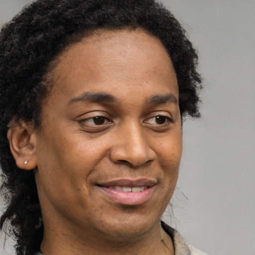 Joyful black adult male with short  brown hair and brown eyes