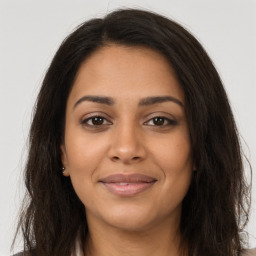 Joyful latino young-adult female with long  brown hair and brown eyes