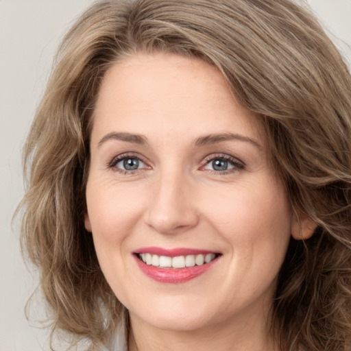 Joyful white young-adult female with long  brown hair and green eyes