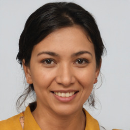 Joyful latino young-adult female with medium  brown hair and brown eyes