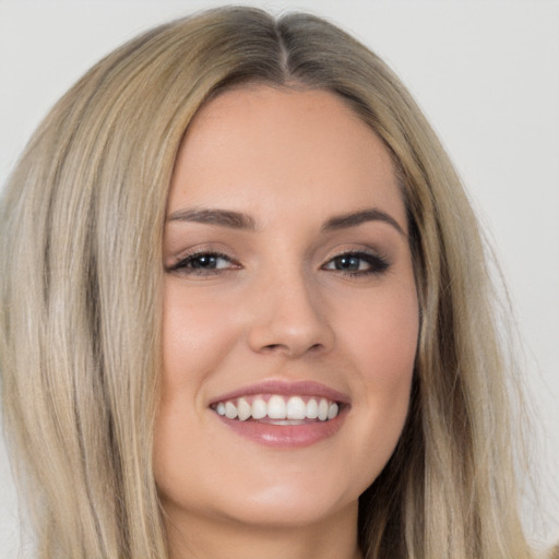 Joyful white young-adult female with long  brown hair and brown eyes