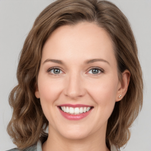 Joyful white young-adult female with medium  brown hair and green eyes