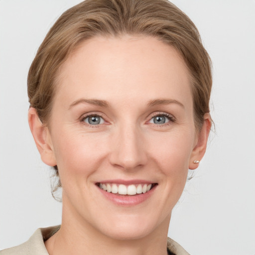 Joyful white young-adult female with medium  brown hair and blue eyes