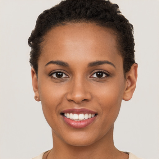 Joyful black young-adult female with short  brown hair and brown eyes