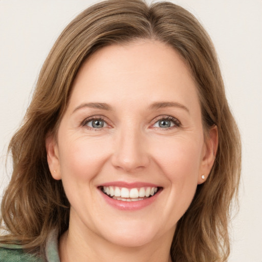 Joyful white young-adult female with medium  brown hair and green eyes