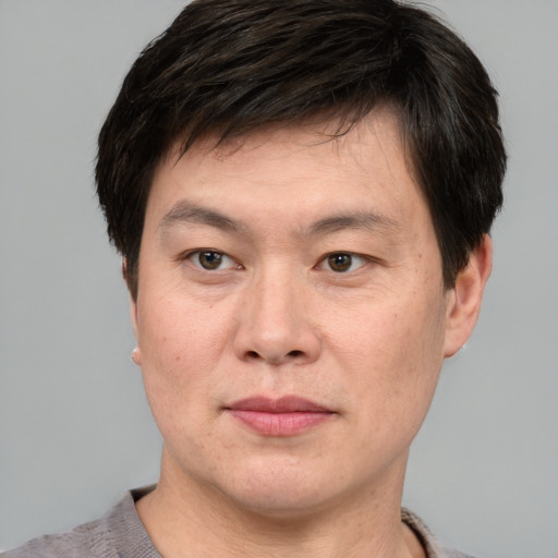 Joyful asian adult male with short  brown hair and brown eyes