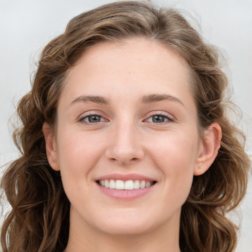 Joyful white young-adult female with long  brown hair and blue eyes