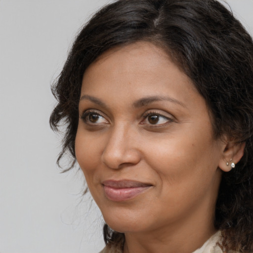 Joyful black adult female with long  brown hair and brown eyes