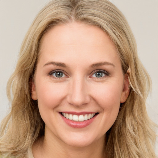 Joyful white young-adult female with long  brown hair and blue eyes