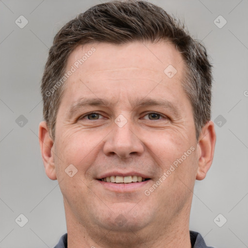 Joyful white adult male with short  brown hair and grey eyes