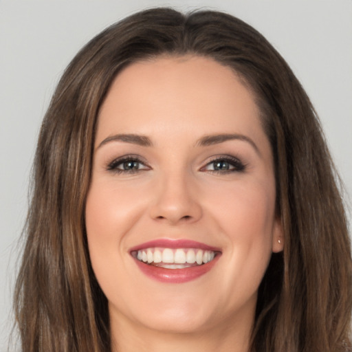 Joyful white young-adult female with long  brown hair and brown eyes