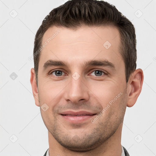 Joyful white young-adult male with short  brown hair and brown eyes