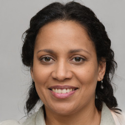 Joyful latino adult female with medium  brown hair and brown eyes