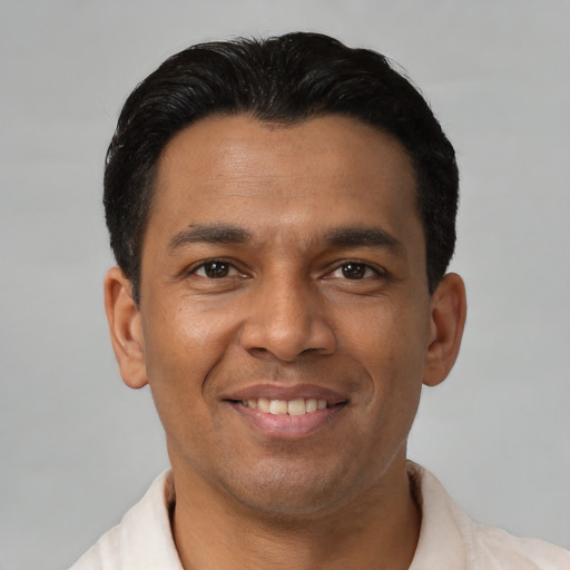 Joyful latino young-adult male with short  black hair and brown eyes