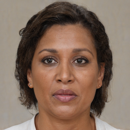 Joyful black adult female with medium  brown hair and brown eyes