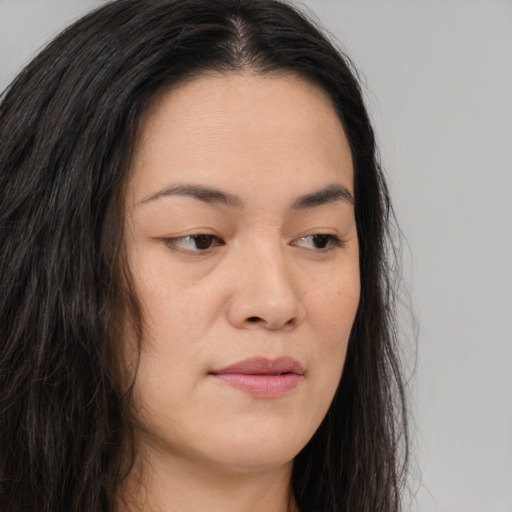 Joyful asian young-adult female with long  brown hair and brown eyes