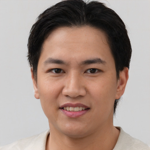 Joyful asian young-adult male with short  brown hair and brown eyes