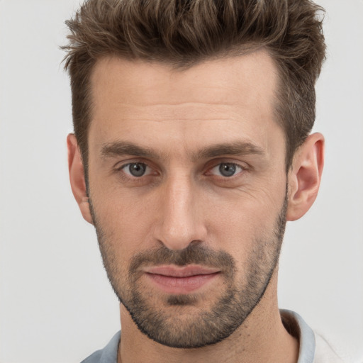 Joyful white young-adult male with short  brown hair and grey eyes