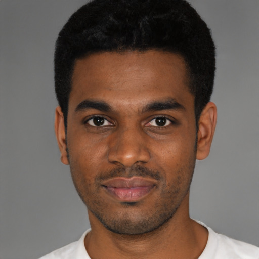 Joyful black young-adult male with short  black hair and brown eyes