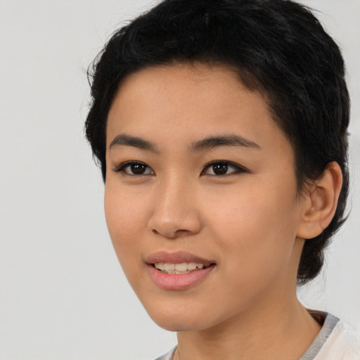 Joyful asian young-adult female with short  black hair and brown eyes