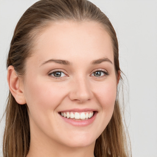 Joyful white young-adult female with long  brown hair and blue eyes