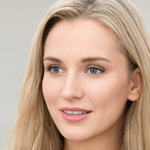 Joyful white young-adult female with long  brown hair and blue eyes