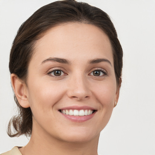 Joyful white young-adult female with medium  brown hair and grey eyes