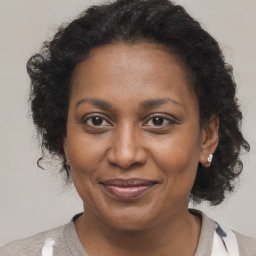 Joyful black adult female with medium  brown hair and brown eyes