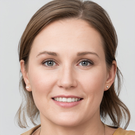 Joyful white young-adult female with medium  brown hair and grey eyes