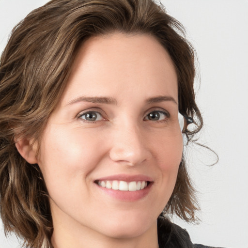 Joyful white young-adult female with medium  brown hair and blue eyes