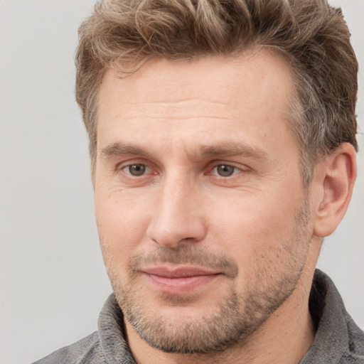 Joyful white adult male with short  brown hair and grey eyes