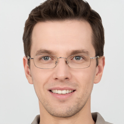 Joyful white young-adult male with short  brown hair and grey eyes