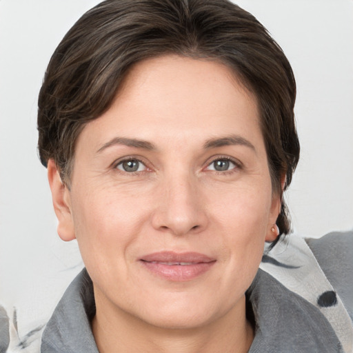 Joyful white adult female with medium  brown hair and grey eyes