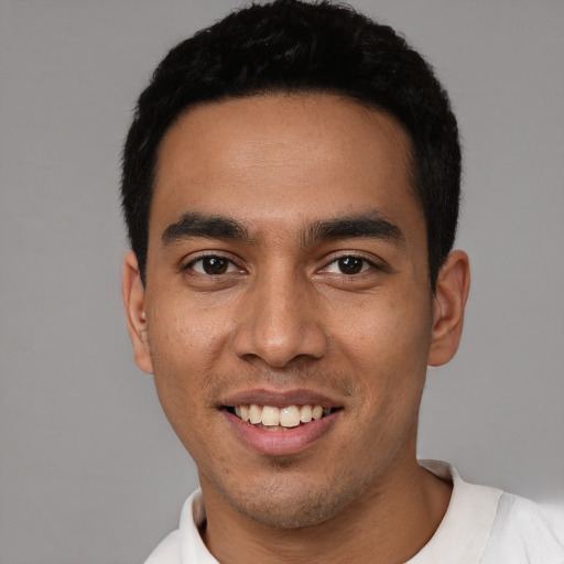 Joyful latino young-adult male with short  black hair and brown eyes