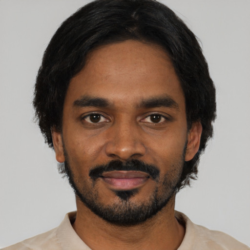 Joyful black young-adult male with short  black hair and brown eyes