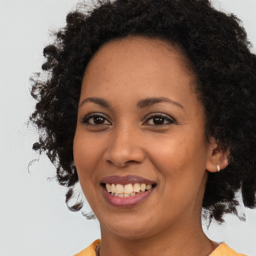Joyful black young-adult female with medium  brown hair and brown eyes