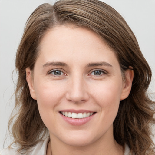 Joyful white young-adult female with long  brown hair and grey eyes